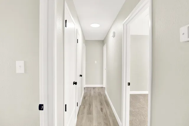 a view of a hallway with wooden floor and staircase