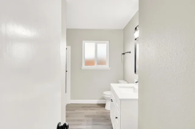 a bathroom with a sink a toilet and mirror