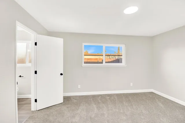 an empty room with windows and closet