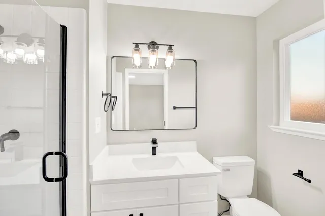 a bathroom with a sink vanity mirror and shower