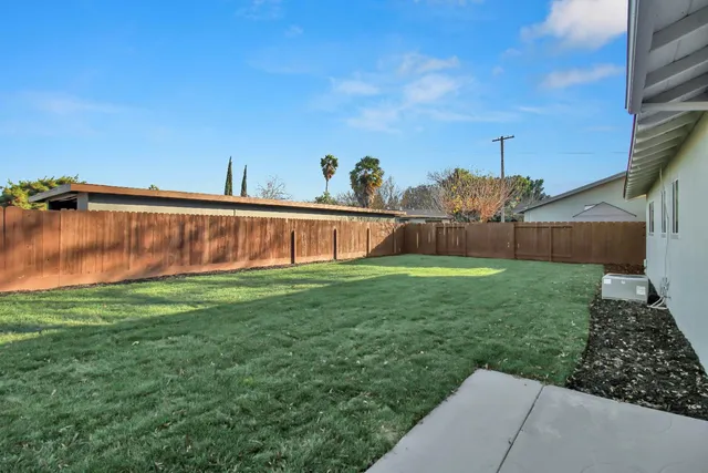 a view of a back yard of the house with a big yard