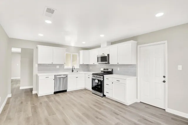 a large kitchen with a stove top oven sink and cabinets