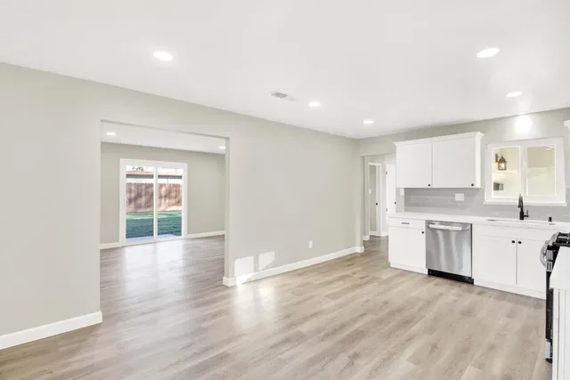 a view of a kitchen with a sink stove and wooden floor