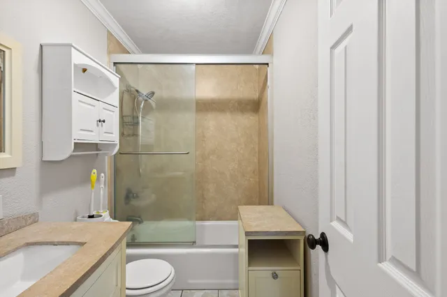 a bathroom with a granite countertop sink toilet and shower