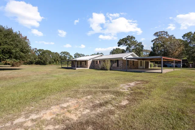 a front view of a house with a garden and trees