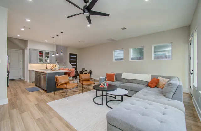 a living room with furniture and a wooden floor