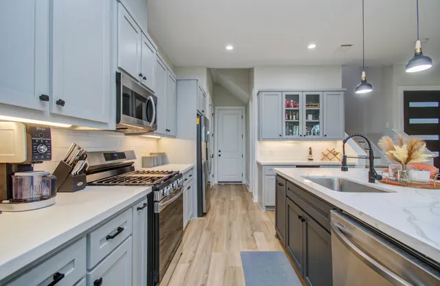 a kitchen with stainless steel appliances granite countertop a sink stove and refrigerator