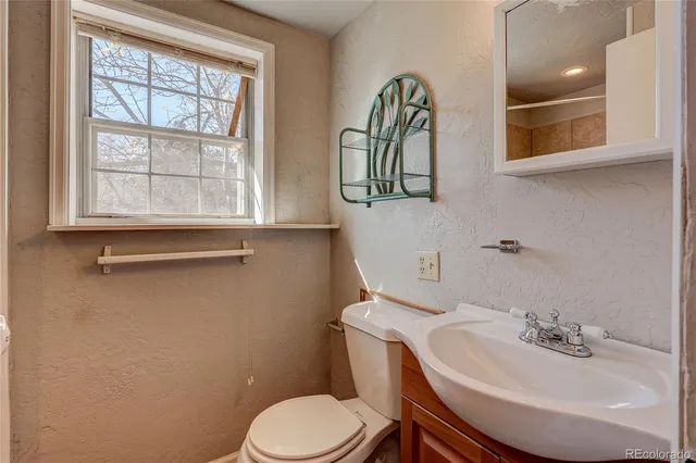 a bathroom with a sink a toilet and a mirror