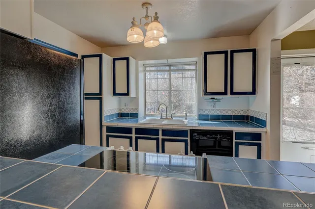 a dining room with wooden floor a chandelier a wooden table and chairs