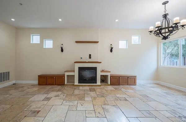 a view of a livingroom with a fireplace cabinet and windows