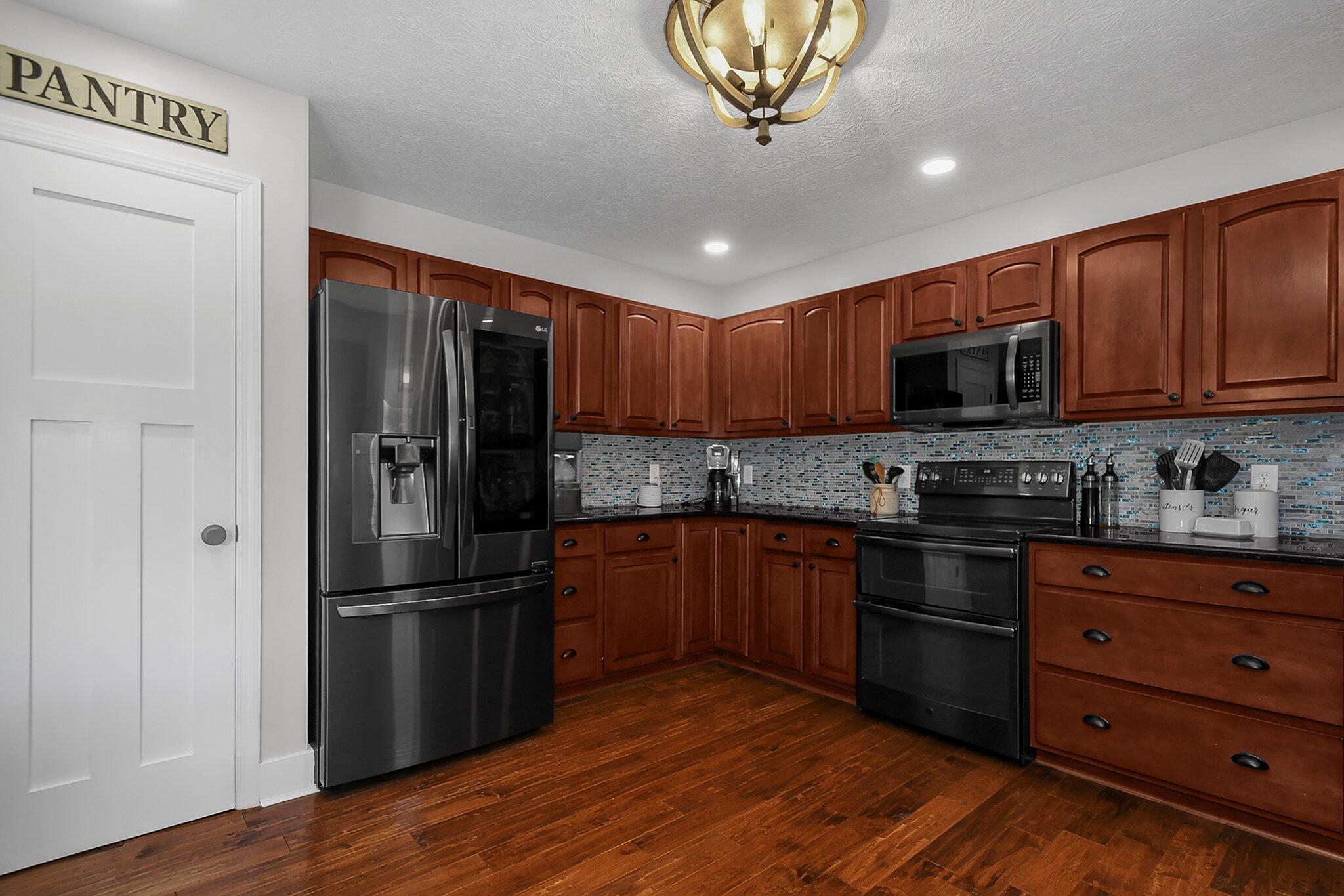 3620 Hyatts Road Powell, OH 43065 - Photo 17 of 54 Kitchen with pantry, granite countertops and glass tile backsplash.