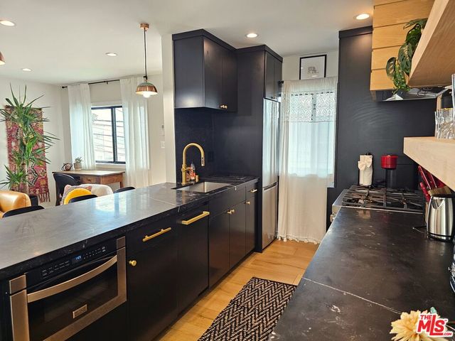 a kitchen with stainless steel appliances a sink stove and refrigerator
