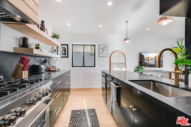 a kitchen with stainless steel appliances granite countertop a sink stove and cabinets