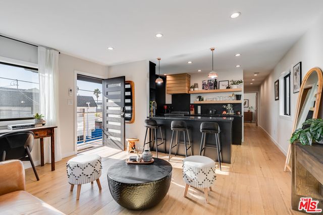 a kitchen with stainless steel appliances wooden floor dining table and chairs