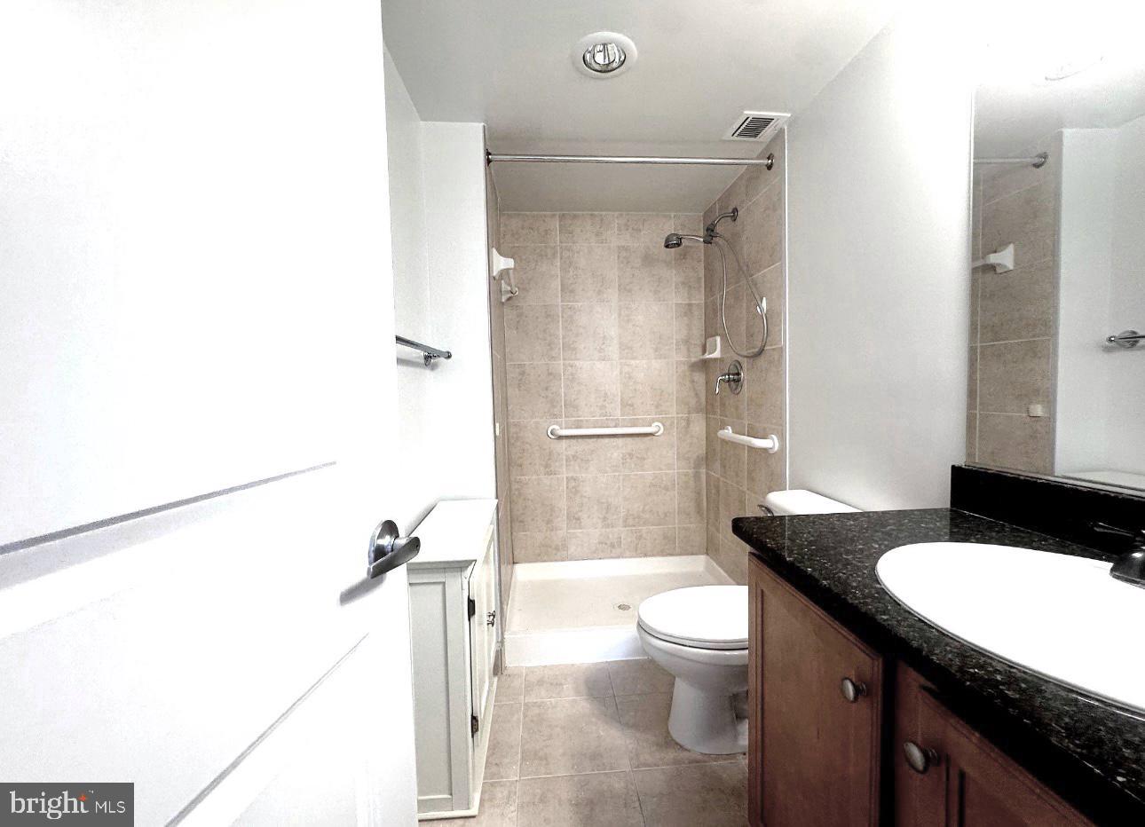 1220 Blair Mill Road, Unit 405 Silver Spring, MD 20910 - Photo 29 of 39 a bathroom with a granite countertop sink toilet a mirror and shower