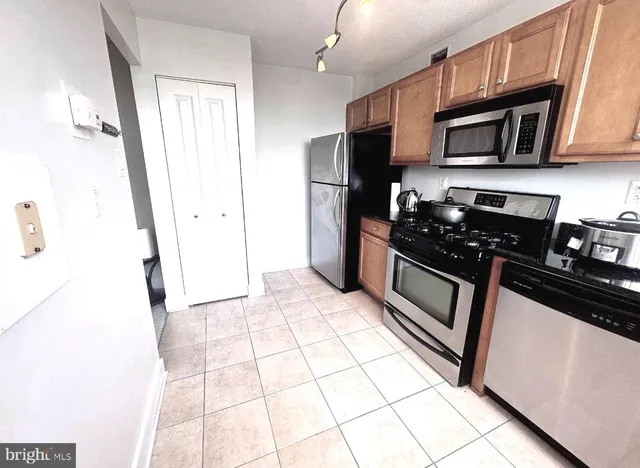 a kitchen with stainless steel appliances a refrigerator a stove a microwave and cabinets