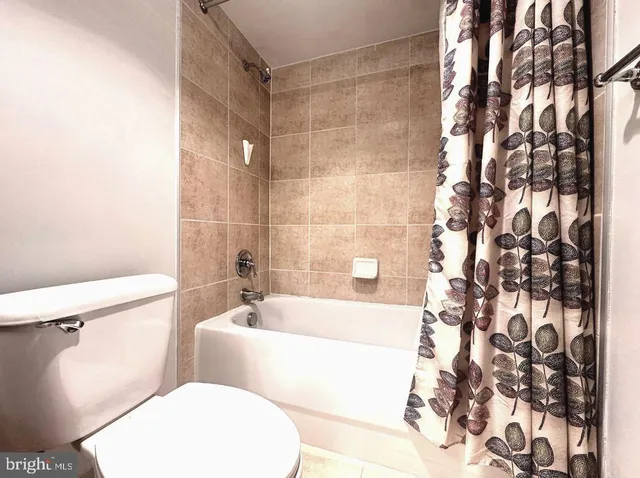 a white toilet sitting next to a bath tub