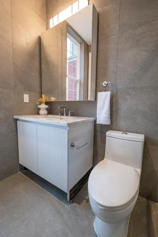 a bathroom with a toilet sink and mirror