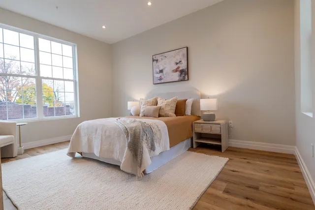 a spacious bedroom with a bed and a large window