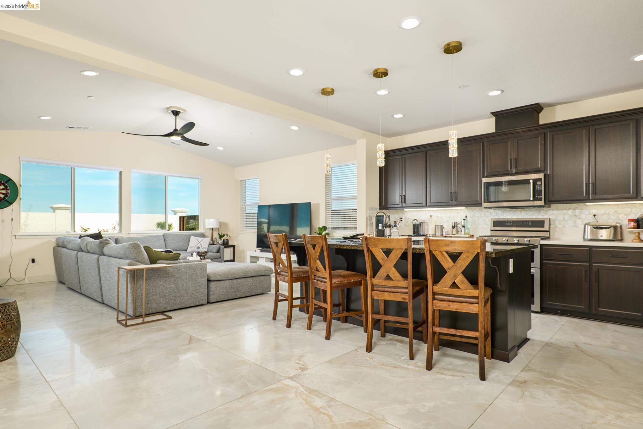 5532 Promontory Way Antioch, CA 94531 - Photo 4 of 45 Kitchen with a breakfast bar, a center island with sink, stainless steel appliances, decorative backsplash, and healthy amount of natural light