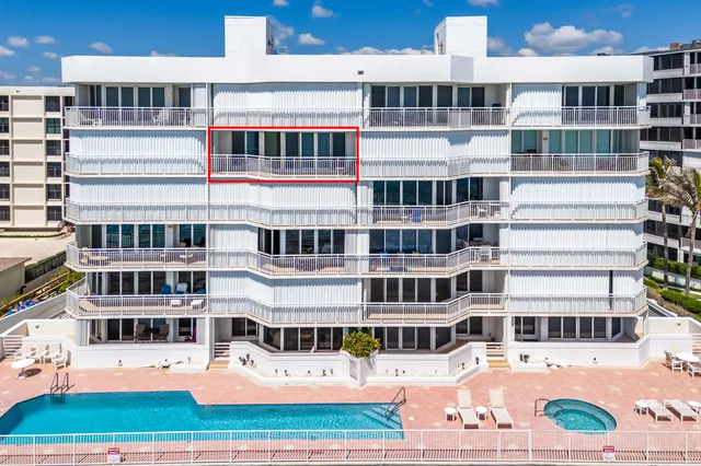 a view of a balcony with two chairs and a yard