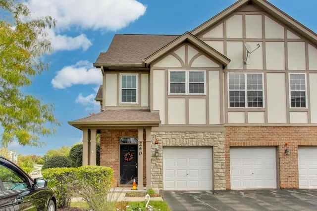 a front view of a house with a garden and plants