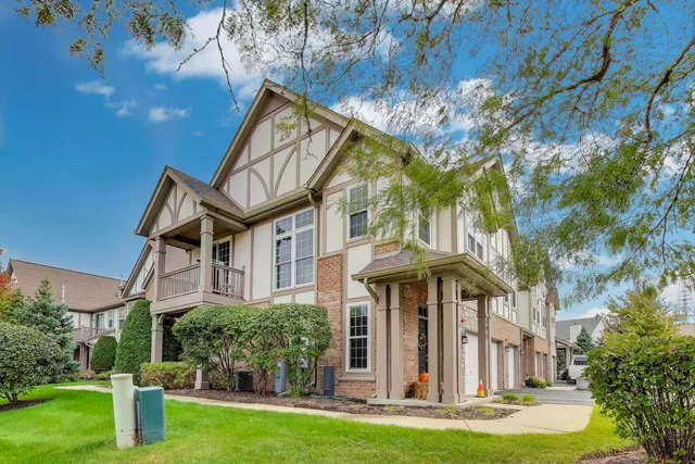 a front view of a house with a yard and trees