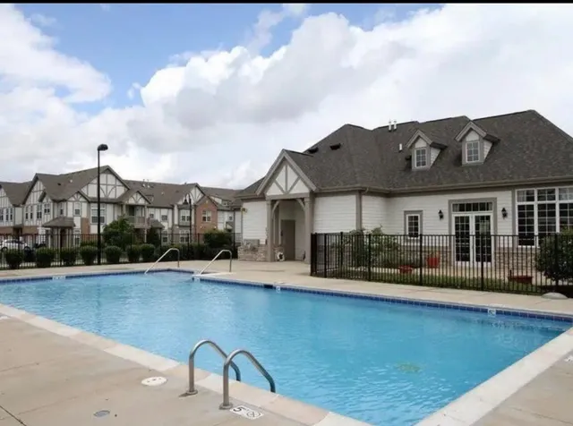 a front view of house and yard with swimming pool and furniture