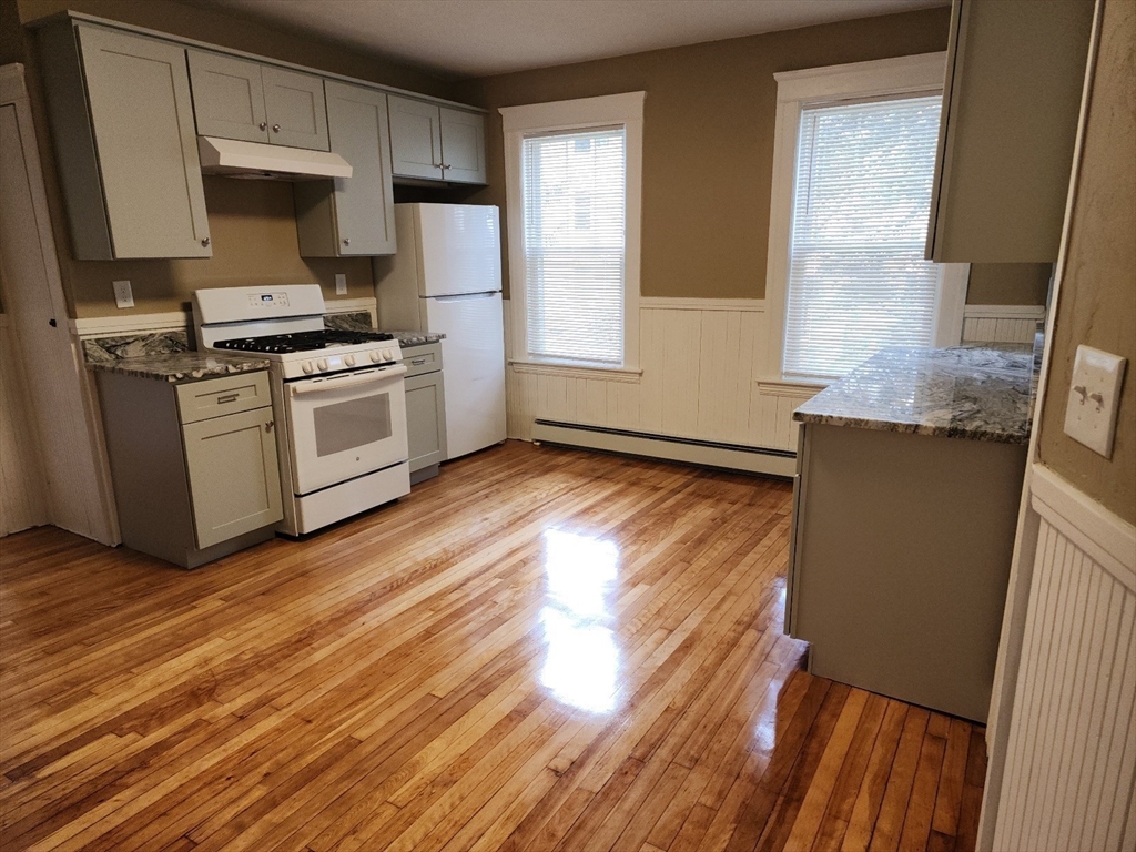 63 Fifth Avenue, Unit 1 Worcester, MA 01607 - Photo 1 of 13 a kitchen with granite countertop a stove a sink and a refrigerator