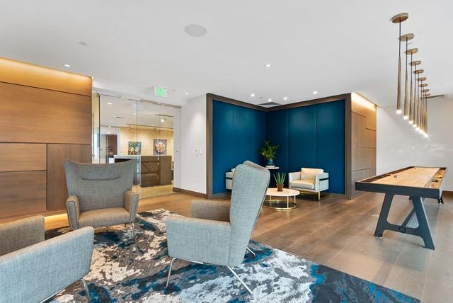 a kitchen with kitchen island granite countertop a stove top oven a sink dishwasher a dining table and chairs with wooden floor