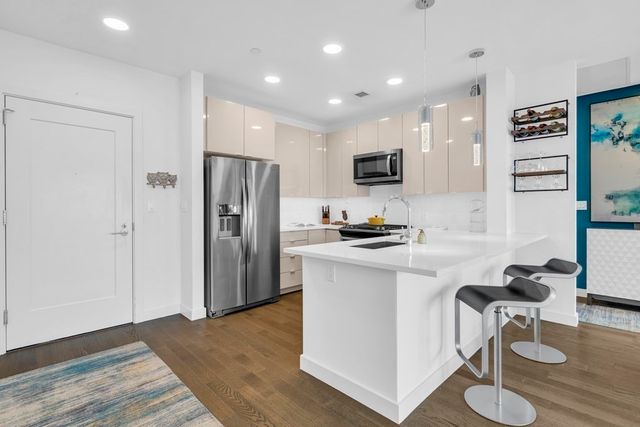 a kitchen with a refrigerator a stove top oven a sink and cabinets