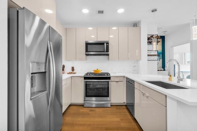 a kitchen with a sink stainless steel appliances and cabinets