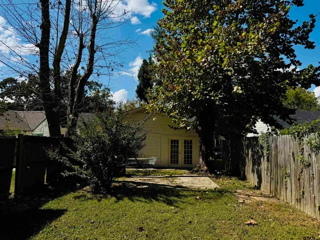 a view of house with yard and outdoor seating
