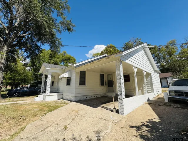 a view of a white house with a yard