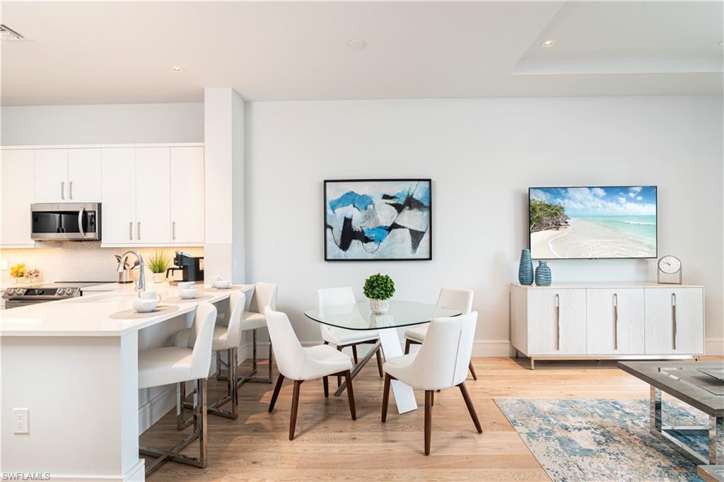 101 8th Street South, Unit 202 Naples, FL 34102 - Photo 6 of 6 a view of a dining room with furniture and wooden floor
