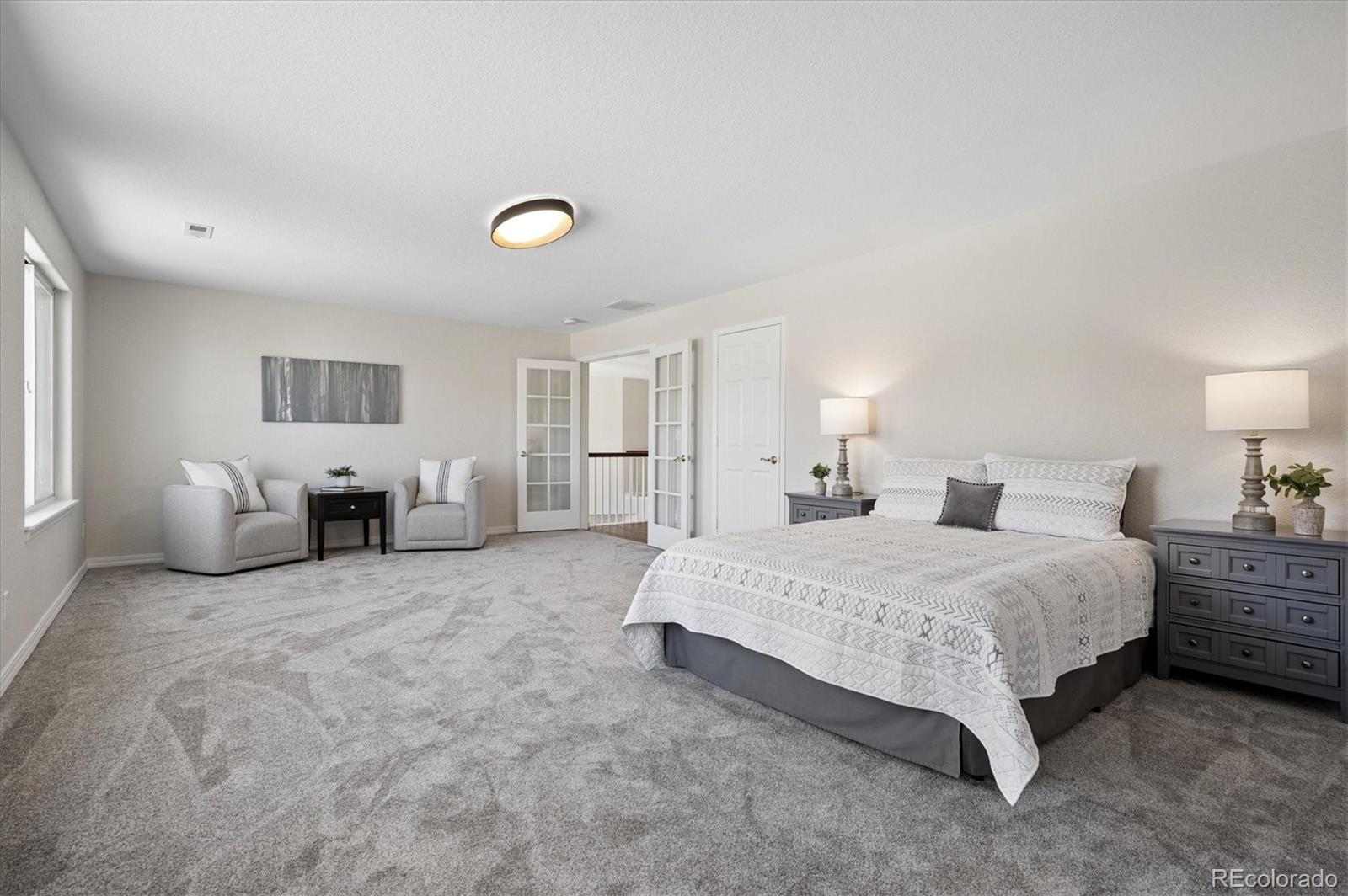 167 South Rogers Way Golden, CO 80401 - Photo 34 of 50 a spacious bedroom with a bed and a lamp