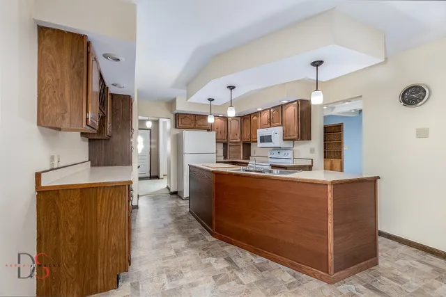 a large kitchen with stainless steel appliances granite countertop a stove and a refrigerator