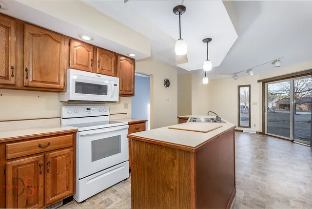 a kitchen with stainless steel appliances granite countertop a sink a stove and a refrigerator