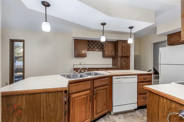 a kitchen that has a sink a stove and a refrigerator