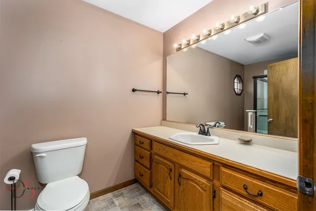 a bathroom with a toilet a sink and mirror