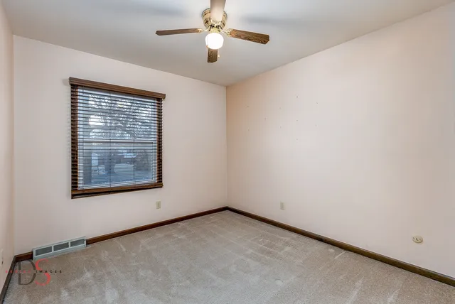 an empty room with a window and a ceiling fan