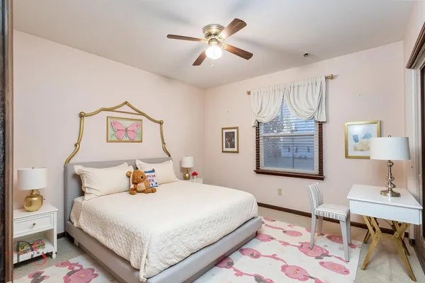 a bedroom with a bed and a table in it with window