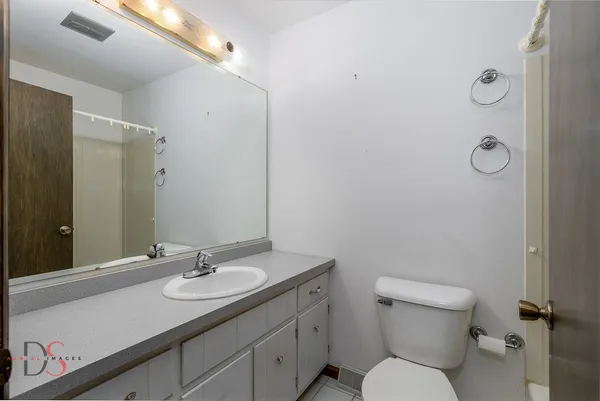 a bathroom with a granite countertop sink toilet and mirror
