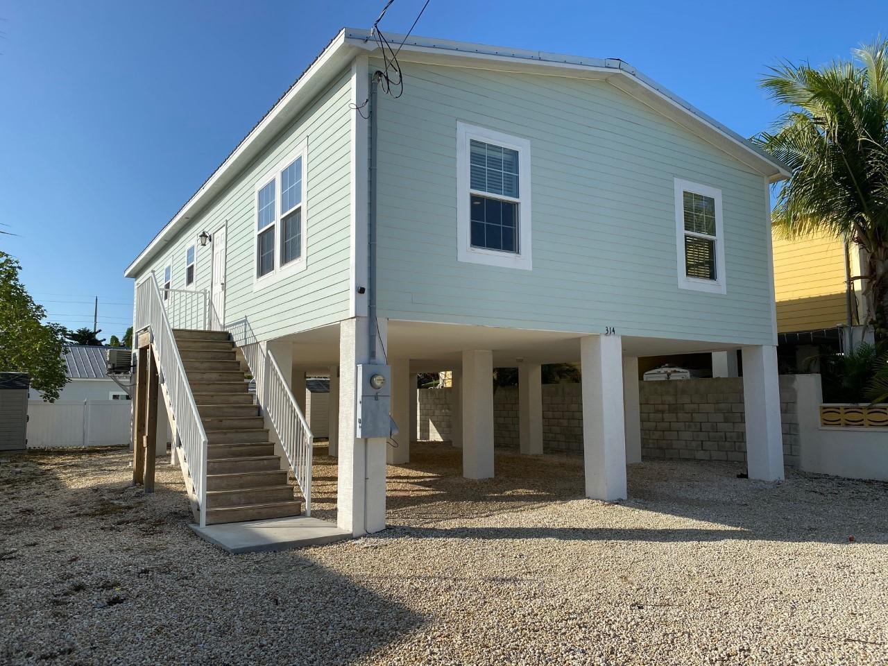 a view of a house with wooden deck and furniture