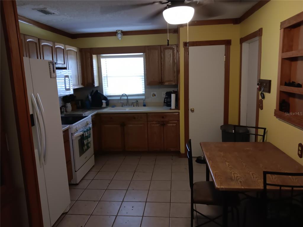374 3rd Street Northwest Largo, FL 33770 - Photo 14 of 31 a kitchen with a sink a stove cabinets and a refrigerator