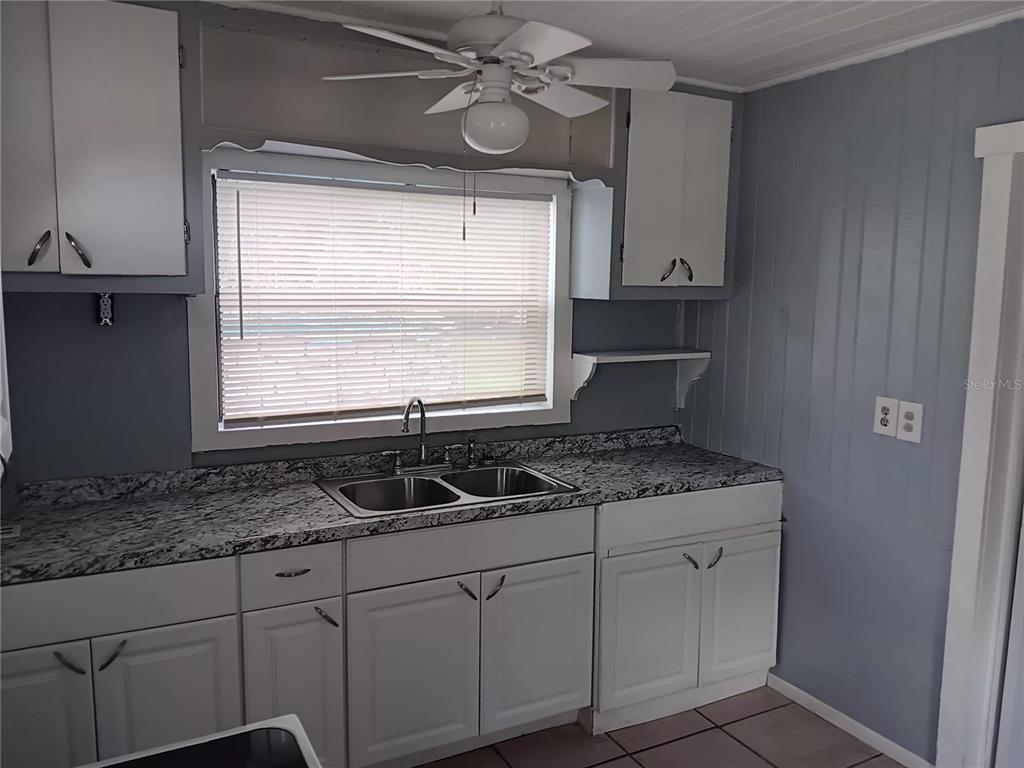 374 3rd Street Northwest Largo, FL 33770 - Photo 27 of 31 a kitchen with a granite countertop sink cabinets window and stainless steel appliances