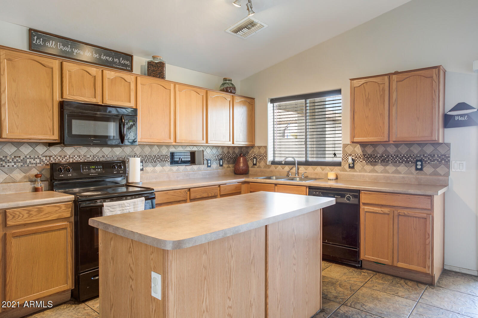 1114 East Fraktur Road Phoenix, AZ 85040 - Photo 9 of 23 a kitchen with a stove a sink a microwave a window and cabinets