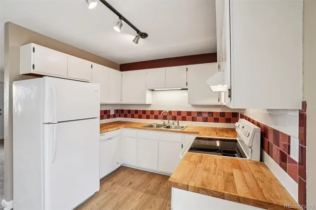 a kitchen with white cabinets sink and white appliances