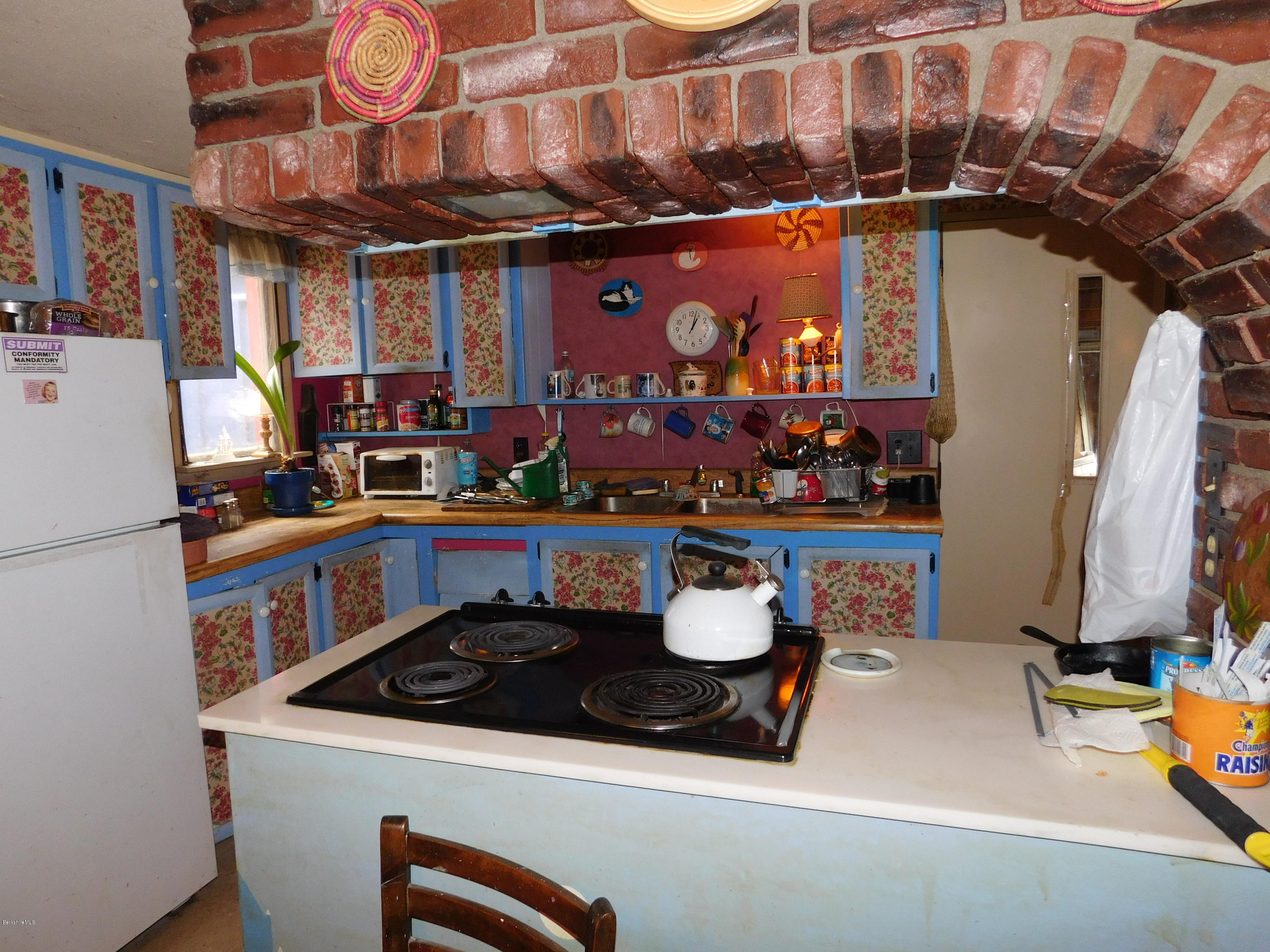 94 River Road Savoy, MA 01256 - Photo 19 of 36 a kitchen with a stove a refrigerator and a dining table