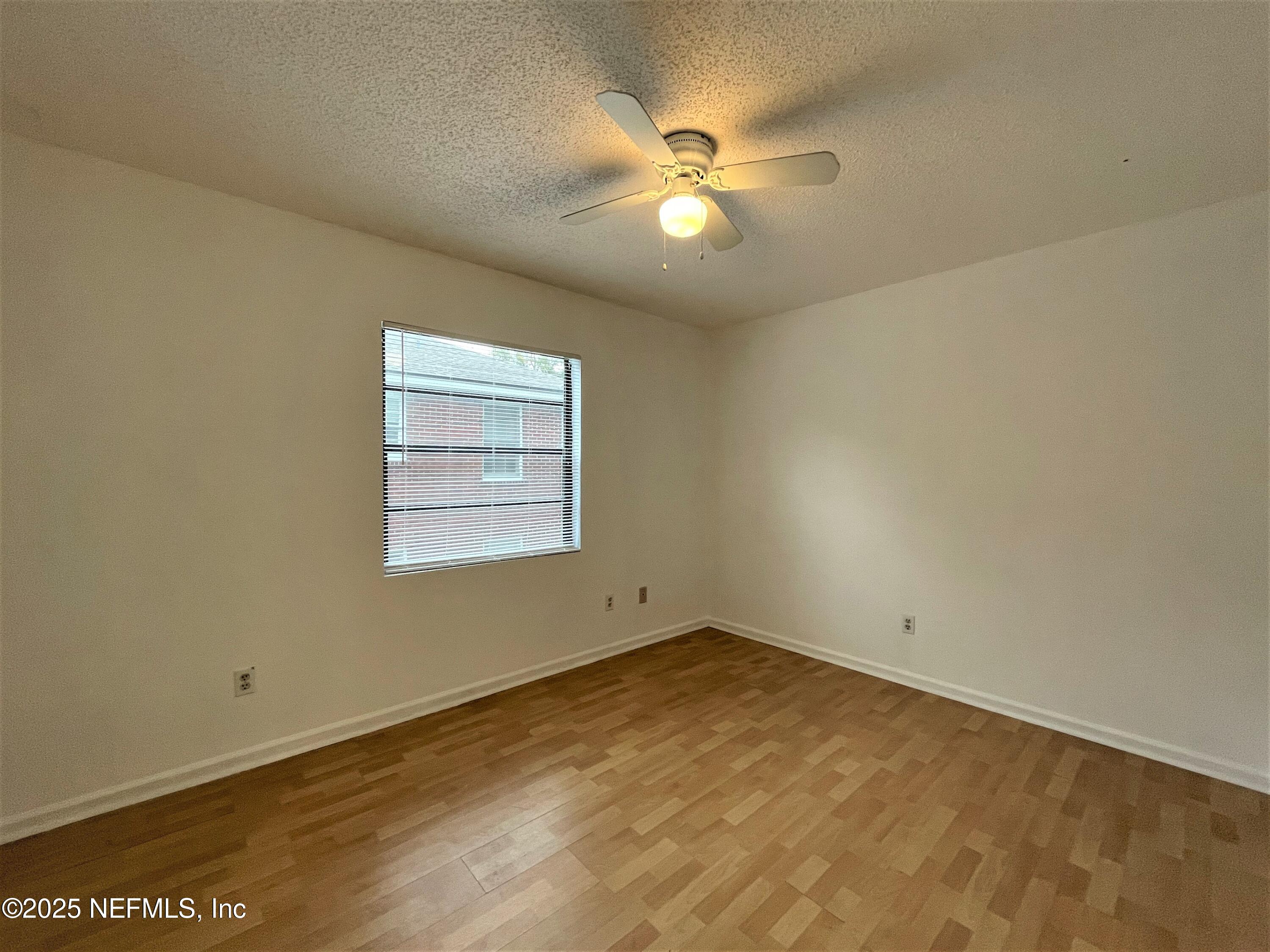 2910 Post Street Jacksonville, FL 32205 - Photo 11 of 12 an empty room with a chandelier fan and windows